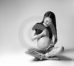 Beauty of young pregnant woman on grey background