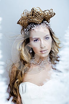 Beauty young snow queen with hair crown on her head, complicate