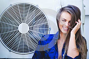 Beauty young woman with air conditioning. near the fan happy laughing. Long hair. Fashionable lady with a beautiful hairdo, makeup