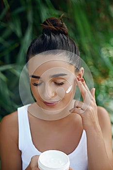 Beauty young woman applying cream to her face. Skin care and cosmetics concept. Cosmetics. Woman face skin care.Natural makeup, to