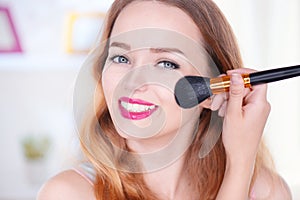 Beauty young woman applying makeup