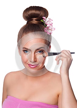 Beauty young woman brushing concealer under eyes