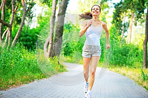 Beauty young woman with earphones running in the park