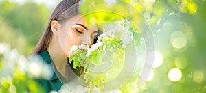 Beauty young woman enjoying nature in spring apple orchard, Happy beautiful girl in a garden with blooming fruit trees