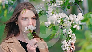 Beauty young woman enjoying nature in spring apple orchard, Happy Beautiful girl in Garden with blooming trees. Aroma