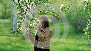 Beauty young woman enjoying nature in spring apple orchard, Happy Beautiful girl in Garden with blooming trees. Aroma