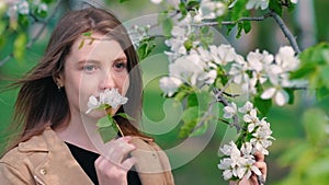 Beauty young woman enjoying nature in spring apple orchard, Happy Beautiful girl in Garden with blooming trees. Aroma