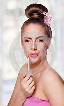 Beauty young woman face with lipgloss photo