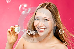 Beauty young woman making soap bubbles