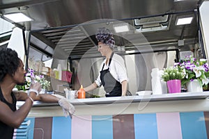 Beauty and young woman works in a food truck