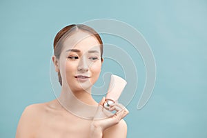 Beauty Youth Skin Care Concept - Beautiful Caucasian Woman Face Portrait holding and presenting cream tube product