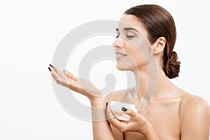 Beauty Youth Skin Care Concept - Beautiful Caucasian Woman Face Portrait smiling and holding cream jar for body and skin