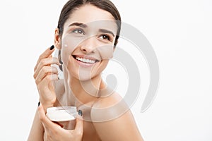 Beauty Youth Skin Care Concept - Close up Beautiful Caucasian Woman Face Portrait applying some cream to her face