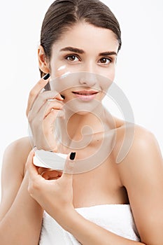 Beauty Youth Skin Care Concept - Close up Beautiful Caucasian Woman Face Portrait applying some cream to her face