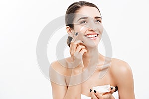 Beauty Youth Skin Care Concept - Close up Beautiful Caucasian Woman Face Portrait applying some cream to her face