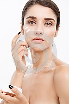 Beauty Youth Skin Care Concept - Close up Beautiful Caucasian Woman Face Portrait applying some cream to her face