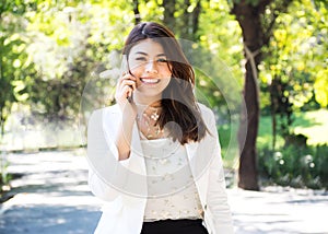 Beautyful business woman walking and using smart phone in park.