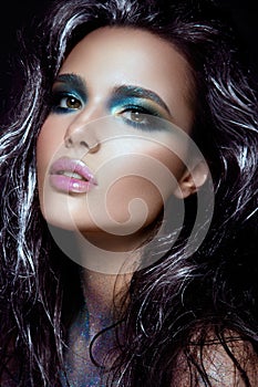 Beautyful girl with blue glitter on her face