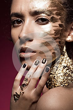 Beautyful girl with gold glitter on her face. Art image beauty