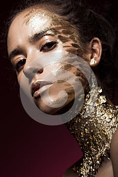 Beautyful girl with gold glitter on her face. Art image beauty