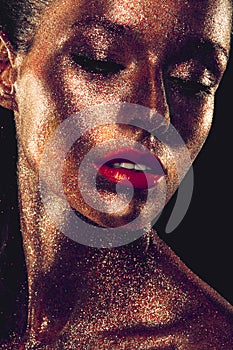 Beautyful girl with gold glitter on her face