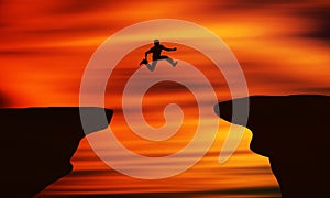 Brave Man jumping off The Cliff In Front of Beautiful orange Sunset.