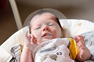 Bebe with yellow and white body lying on baby hammock