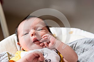 Bebe with yellow and white body lying on baby hammock