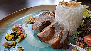 Bebek areh sambal matah is Indonesian traditional food, savory duck meat combined with fresh matal sauce photo