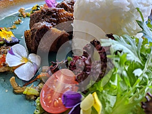 Bebek areh sambal matah is Indonesian traditional food, savory duck meat combined with fresh matal sauce photo