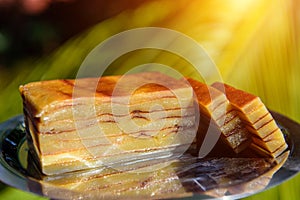 Bebinca, traditional Goan dessert from coconut milk dough, sweet Indian pudding on a metal plate, close up. Goan-Portuguese pie,