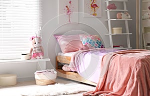 Bed with beautiful linens in children`s room. Modern interior design