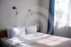 Bed in bedroom lit by sunlight