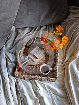 Bed and breakfast with bread, cup of tea and honey