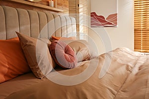 Bed with brown linens in cozy bedroom. Interior design