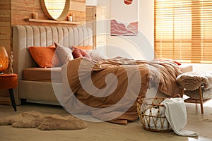 Bed with brown linens in cozy bedroom. Interior design