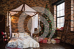 Bed with canopy valance baldachin decorated with decorative pillows with a pattern and lamps . Christmas tree with gifts loft