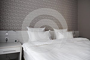 Bed, clean pillows and bed sheets in modern bedroom hotel