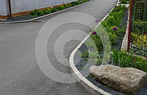 A bed of colorful prairie flowers in an urban environment attractive to insects and butterflies, mulched by gravel. on the corners