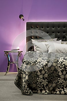 Bed in front of a purple wall