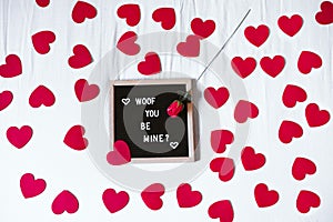 Bed at home by letter board Woof you be mine. Red hearts and rose..Valentines concept