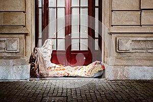 Bed of homeless person in front of urban house, Porto, Portugal