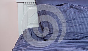 Bed at hotel room. Sleeping time and rest concept. Bedroom at home and soft pillows with blue linens. Selective focus. Banner