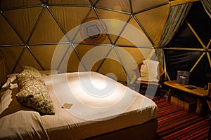 Bed and interior of dome on luxury glamping hotel