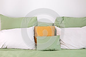 Bed maid-up with clean white pillows and bed sheets. Colorful Pillows on hotel bed