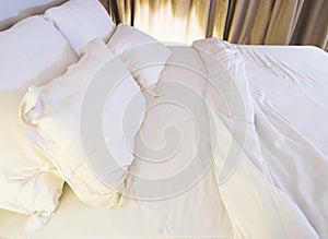 Bed mattress and pillows messed up in bedroom photo