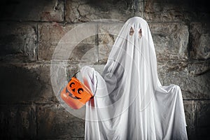 Bed sheet ghost with pumpkin bucket for Halloween