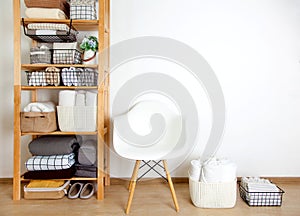 Bed sheets, duvet covers and towels are folded vertically. Metal and fabric black baskets. The concept of housework and storage