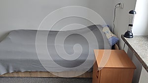 Bed in a small cozy student room in a student dormitory
