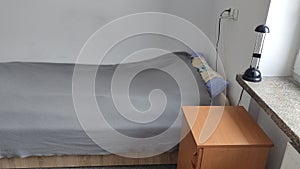 Bed in a small cozy student room in a student dormitory